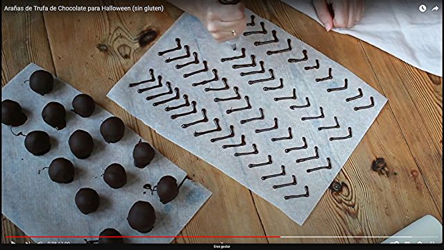 Preparación / Pasos Arañas de Trufa De Chocolate De Halloween Sin Gluten - Paso 4) Con el chocolate sobrante rellenar un biberón con una boquilla del número 2. Dibujar sobre papel de horno las patas de las arañas y dejar solidificar.